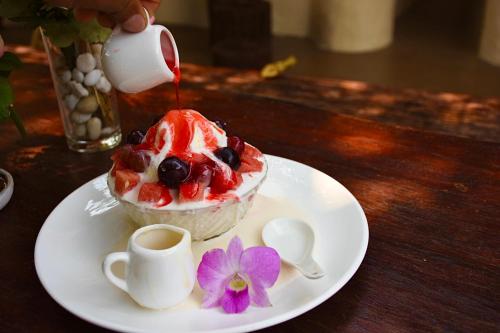 a dessert on a white plate with a cup of coffee at Ban Rai Jai Chaem - Spa Cafe & Homestay in Ban Rai