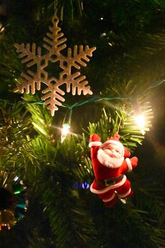 a santa claus ornament hanging from a christmas tree at Ban Rai Jai Chaem - Spa Cafe & Homestay in Ban Rai