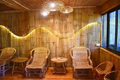a group of chairs and tables in a room at Ban Rai Jai Chaem - Spa Cafe & Homestay in Ban Rai