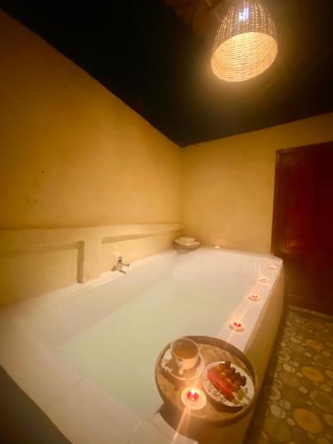 a bathroom with a tub with a table in it at Ban Rai Jai Chaem - Spa Cafe & Homestay in Ban Rai