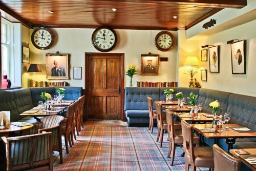 een restaurant met tafels en stoelen en klokken aan de muur bij The Sportsman's Arms in Harrogate