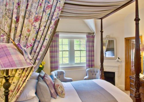 a bedroom with a canopy bed and a fireplace at The Sportsman's Arms in Harrogate