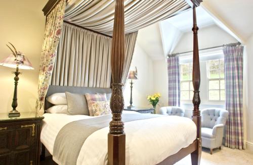 a bedroom with a canopy bed and a chair at The Sportsman's Arms in Harrogate