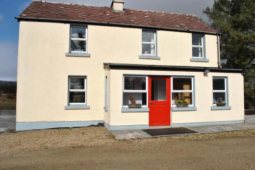 a small white house with a red door at Douglas Lodge Holiday Homes in Keadew