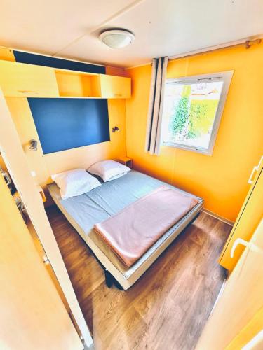 une petite chambre avec un lit dans une petite pièce dans l'établissement L'éveil des sens, à Saint-Chéron
