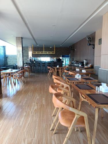 a dining room with wooden tables and chairs at Grand Samota Hotel in Sumbawa Besar