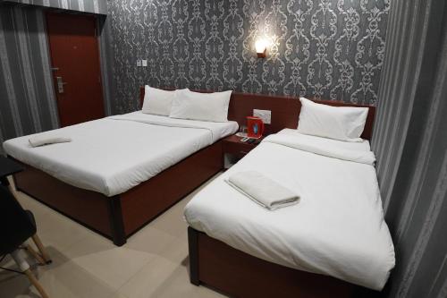 two beds in a hotel room with white sheets at HOTEL PARK VICTORIA in Kolkata