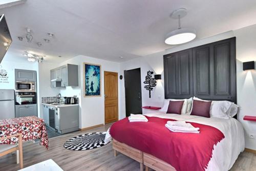 une chambre avec un grand lit et une cuisine dans l'établissement Les Suites Fénelon, à Le Cateau