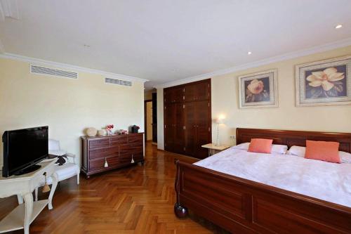 a bedroom with a bed and a desk and a television at Villa Northern Star in Alcudia