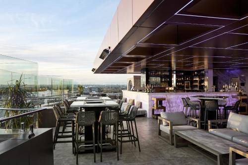 a restaurant with a bar with chairs and tables at Crowne Plaza Sydney Burwood by IHG in Sydney