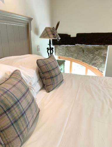 a bedroom with a bed with two pillows on it at The Sportsman's Arms in Harrogate