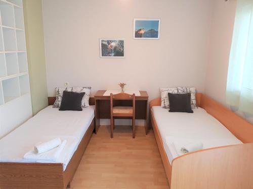 2 łóżka w małym pokoju ze stołem w obiekcie Kornati - Apartments & Stone cottage w mieście Kornati