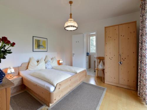 a bedroom with a large white bed and a door at Rosenhof am See Ferienwohnung Alpenrose in Thiersee