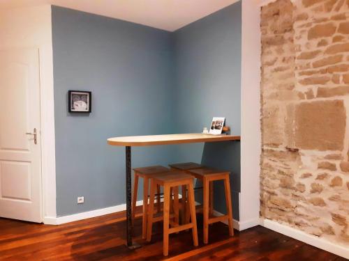 stół i stołki w pokoju z niebieską ścianą w obiekcie Cordeliers Jordans Flat City centre historique w mieście Dijon