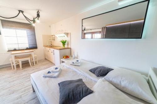 a bedroom with two beds and a large mirror at Promenada Apartamenty i Domek Nad Jeziorem in Mikołajki