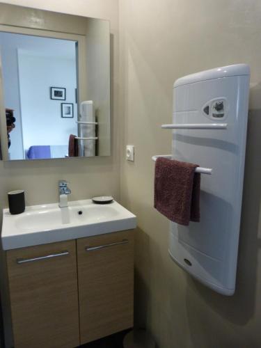 een badkamer met een witte wastafel en een spiegel bij Appartement Topaze Bourg d'Oisans in Le Bourg-dʼOisans
