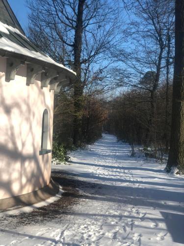 a snow covered road with a building and trees at Hotel Restaurant Krone in Hayna