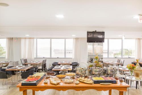 a table with food on it in a room with windows at Iate Hotel Centro Florianópolis in Florianópolis