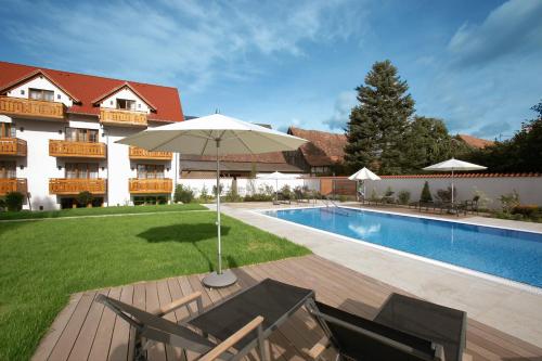 a patio with an umbrella next to a swimming pool at Hotel Restaurant Krone in Hayna