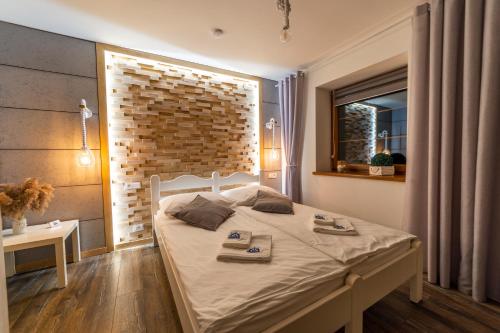 sypialnia z łóżkiem i ceglaną ścianą w obiekcie Promenada Apartamenty i Domek Nad Jeziorem w mieście Mikołajki