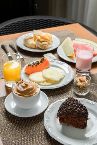 a table with plates of food on a table at Iate Hotel Centro Florianópolis in Florianópolis