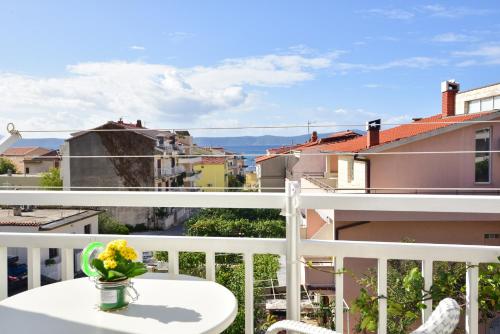 a balcony with a table and a view of a city at Apartmani Mira Sumić in Podgora