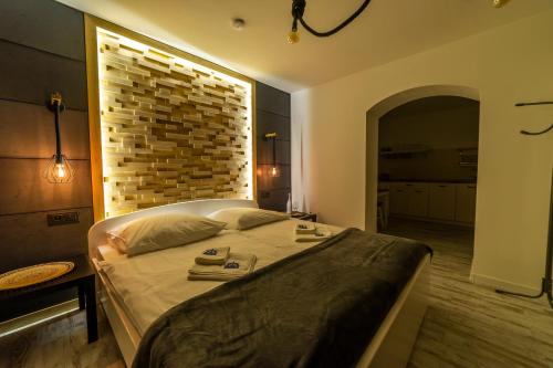 a bedroom with a large bed with a brick wall at Promenada Apartamenty i Domek Nad Jeziorem in Mikołajki