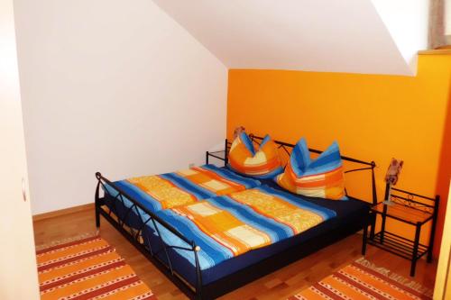 1 dormitorio con 1 cama con sábanas y almohadas coloridas en Ferienwohnung Schrittwieser, en Faak am See