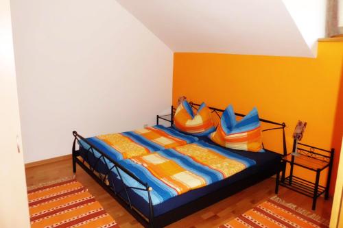 a bedroom with a bed with colorful sheets and pillows at Ferienwohnung Schrittwieser in Faak am See