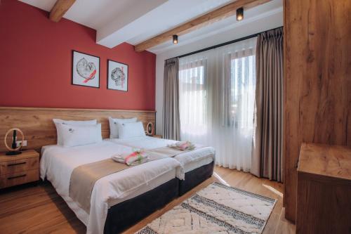 een slaapkamer met een groot bed met rode muren bij Pearl Apartments in Ohrid