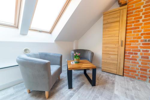 a room with two chairs and a table and a window at Promenada Apartamenty i Domek Nad Jeziorem in Mikołajki