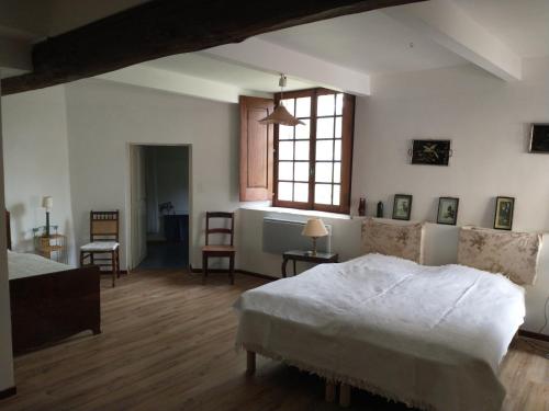 a bedroom with a white bed and a window at Concièrgerie du Château d'Allemagne En Provence in Allemagne-en-Provence