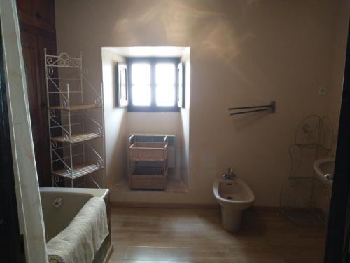 uma casa de banho com uma banheira, um WC e uma janela. em Concièrgerie du Château d'Allemagne En Provence em Allemagne-en-Provence