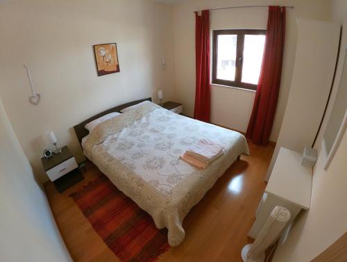 a small bedroom with a bed and a window at Apartmani Roić in Stari Grad