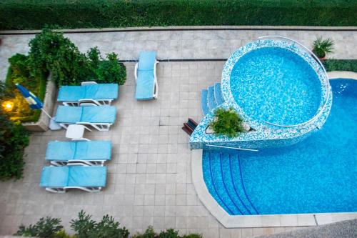 una vista aérea de una piscina con sillas y una mesa en Family Hotel Rainbow, en Sveti Vlas