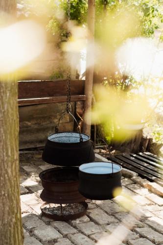 two pots are hanging from a swing on a bench at 'MONAS' house in Bački Monoštor