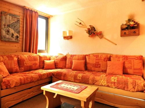 a living room with a couch and a table at Résidence Chanteneige - Freeloc Immobilier in Les Menuires