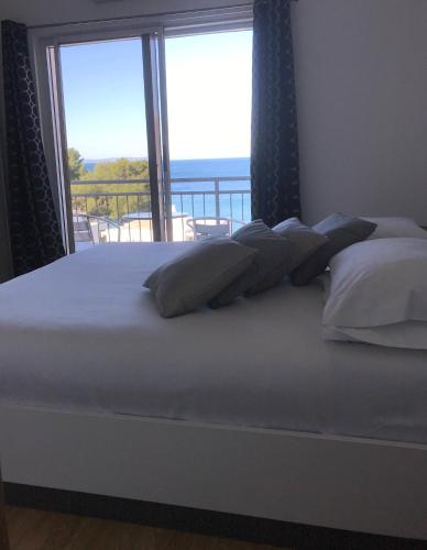 a bedroom with a bed with a view of the ocean at Pink Inn in Podstrana