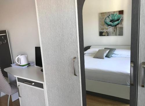 a bedroom with a bed and a desk with a computer at Pink Inn in Podstrana