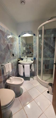 a bathroom with a toilet and a sink and a shower at Hotel Corallo Sperlonga in Sperlonga