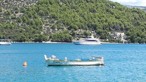 a boat is docked in the water with two boats at Apartman & rooms Draga in Marina