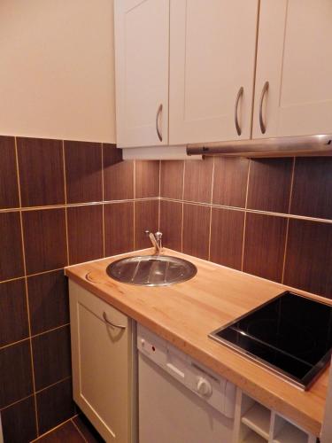 a kitchen with a sink and a counter top at Résidence Chanteneige - Freeloc Immobilier in Les Menuires