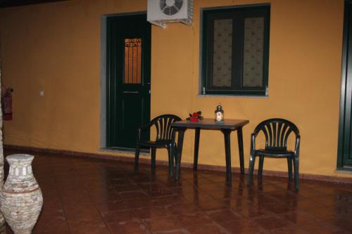 イエリソスにあるEleni Rooms Develikiのドア付きの部屋(テーブル1台、椅子2脚付)