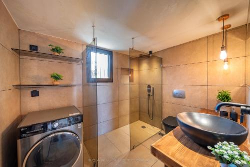 a bathroom with a sink and a washing machine at My Cool House in Porto Heli