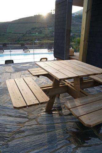 a wooden picnic table sitting on top of a patio at Quinta das Fontainhas in Mesão Frio