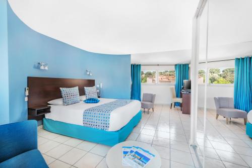 een hotelkamer met een bed met blauwe muren bij La Frégate in Collioure