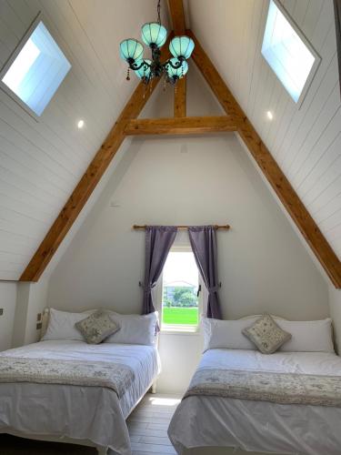 two beds in a attic room with a window at 維瓦利 in Sanxing