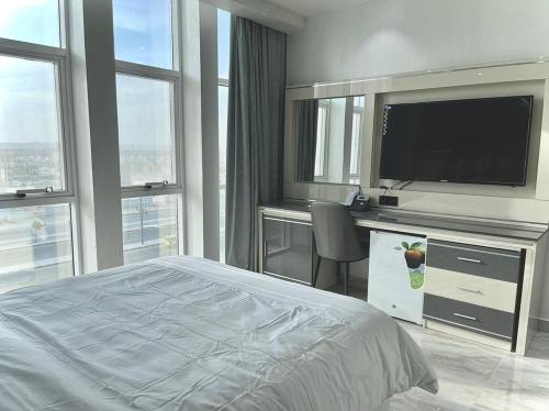 a bedroom with a bed and a flat screen tv at Asian Hotel in Duqm