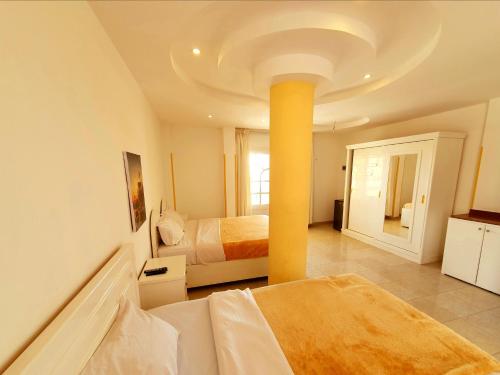 a bedroom with two beds and a yellow pole at Spring Hotel Luxor in Luxor