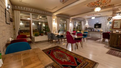 un restaurante con mesas y sillas en una habitación en In Stone House, en Göreme